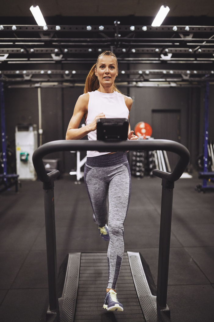 Woman Running on a Treadmill in the Gym